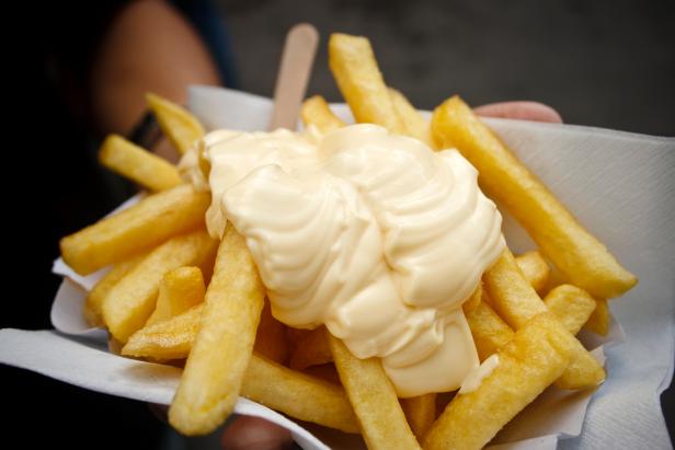 Man holding chips with mayonnaise.