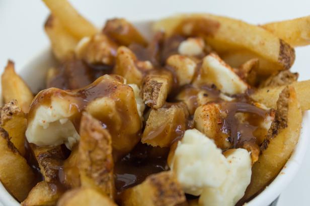 Closeup to a serving of Poutine in Canada which consists of fries, gravy and cheese curds.