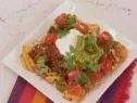 Nacho French Fries was prepared by Food and Lifestyle Expert Brandi Milloy. She takes half of a 20 oz. bag of frozen french fries, cooks them according to the package, and places them onto a platter. She first layers the fries with prepared chili from the can. Next add montary jack cheese, salsa, and a few cherry tomatoes. Add sour creme and pickled jalepenos, finishing it off with some cilantro, as seen on Let's Eat, Season 1.