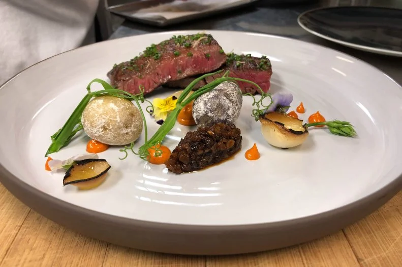 Michael Mina is a busy chef. Between running food halls in Honolulu and cooking for U.S. presidents, he has his hands full. You can find almost every type of food at one of his 30 restaurants, but his most-over-the-top steak is served at regional French restaurant RN47 Seattle. With a little help from Executive Chef Thomas Griese, Mina has concocted a grilled Meyer Ranch skirt steak topped with a veal demi-glaze, smoked pimenton de la Vera aioli, foraged wild-pea vines, Basque-style marbled potatoes and a viola garnish.