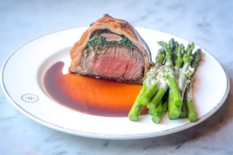 Consistently ranked one of the best steakhouses in Chicago, of course Swift & Sons serves filet mignon, dry-aged Kansas City strip and Japanese A5 strip loin, but its most-over-the-top steak dish is an often forgotten classic: beef Wellington. Served on a wooden cutting board and sliced tableside, the 12-ounce medium-rare tenderloin (meant to serve two) comes topped with foie gras, mushroom duxelles and spinach, all encased in a golden pastry shell.