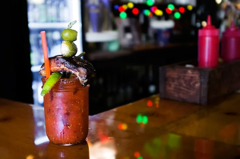 TBG treats its Bloodys in much the same way it approaches its low-and-slow-smoked meats. The chef whips up his own Mary mix (flavored with a dash of BBQ sauce, of course) and uses his all-purpose rub to rim the glass. Jalapeno-infused vodka joins the party, as do celery, olives, limes, pickled veggies and the coup de grace, a hulking smoked rib.