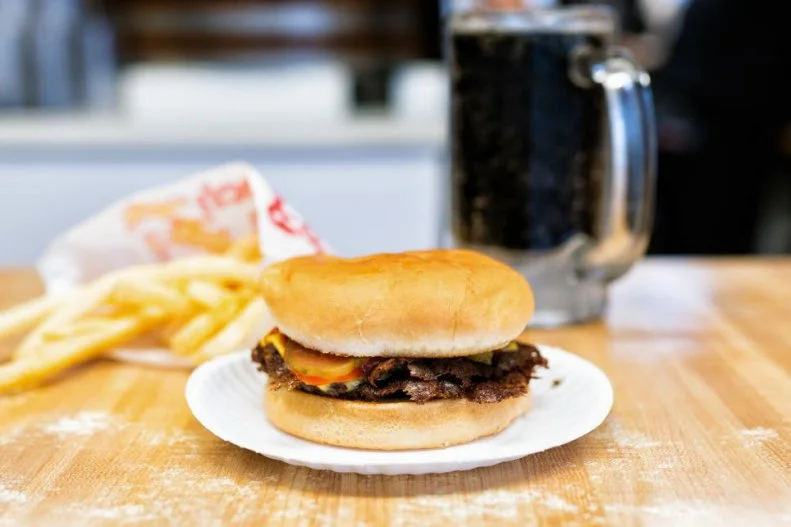 Husband-and-wife team Carl and Pat Meyer began smashing patties on Carl's Drive-In's griddle back in 1959. Nearly 60 years later, locals still line up past the door of this 16-seat restaurant to get a taste of what's considered St. Louis' best burger. These burgers seem to defy the basic laws of physics. Each small patty, about a sixth of a pound, is smashed flat and thin, producing deliciously crispy edges while somehow retaining its juiciness. They're sold by the single, double or triple â   don't feel guilty sizing up â   and come topped with either Swiss or American cheese on griddled white buns with a selection of toppings such as lettuce, tomato, small-diced onions and crispy bacon.