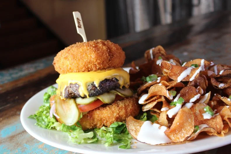 This Tampa place specializes in comfort food with a twist. Fun down-home items on the menu include nachos based on housemade potato chips smothered in chili cheese, and a mac-and-cheese dish enlivened with bacon and jalapenos. One of the best-sellers and most-famous offerings — due to a Good Morning America spot — is the Cheesy Todd. The 100 percent fresh-ground chuck patty is seared, then topped with American cheese, lettuce, tomato, red onion and pickles, and nestled between two fried bacon-jalapeno mac 'n' cheese buns. It's certainly enough on its own, but this signature dish comes with a side of housemade sweet-and-salty chips with creamy blue cheese drizzle and green onions.