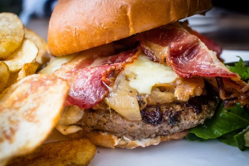 Diners and drinkers descend en masse upon this Uptown gastropub for its creative bar bites and stiff cocktails. The place has a Prohibition-era feel and is hailed for its charcuterie and bistro-style fare prepared through a Texas lens. One of the must-tries is Henry's Marrow Spiked Burger, an Akaushi beef patty glazed in decadent bone marrow with sweet caramelized onions and sharp cheddar cheese, all tucked inside a brioche bun. It's accompanied by housemade pickles and fresh-cut potato chips. If you need to get the stomach juices flowing before biting into this lovely hunk of meat, stop for an aperitif in Atwater Alley, the secret cocktail bar hidden behind Henry's kitchen.