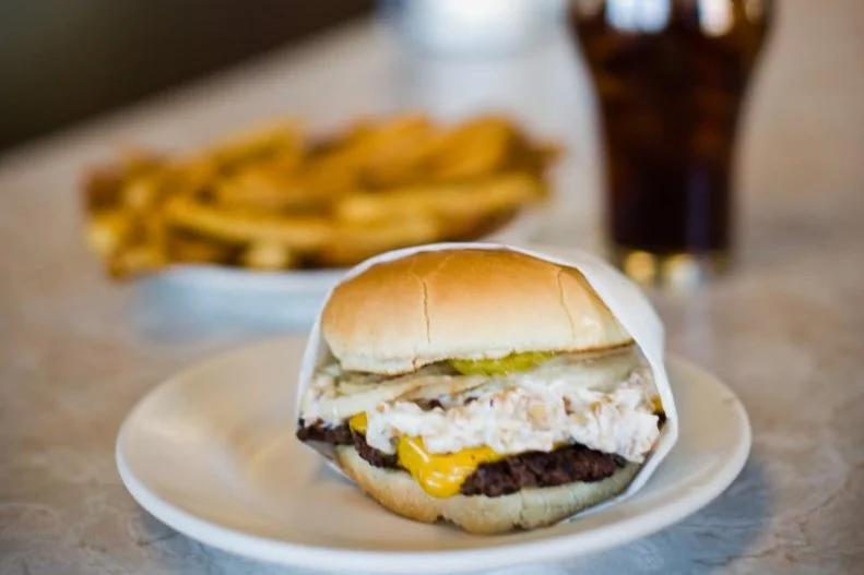 There's a reason the James Beard Foundation gave this 16-seat drive-in an America's Classics Award. Not only is it historic, dating back to 1930, but the foundation called its Nut Burger a "masterpiece [whose] topping melds with sliced pickles, tomatoes, and onions righteously." What, exactly, makes it a nut burger? This patty, made from 100 percent lean Montana beef cooked on a cast-iron grill, is coated with chopped cashews and pecans blended together in a blanket of mayonnaise.