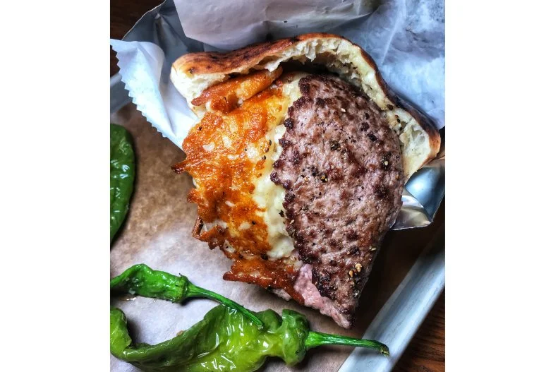 This Tel Aviv-based chain with locations in cities like Paris and Vienna has laid down roots inside NYC's Chelsea Market, bringing its oddly packed pitas stateside. The menu includes classic Mediterranean lamb kebab and ratatouille-filled breads, as well as Americanized stuffings like rib-eye roast beef with mustard and aioli. Then there's the acclaimed folded cheeseburger. A smashed beef patty with a solid char on both sides is â   as its name suggests â   folded in half and laid into a split pita with white cheddar, aioli, sour cream, pickles and tomatoes. This unusual and delightful representation of two international comfort-food staples draws incredibly long lines