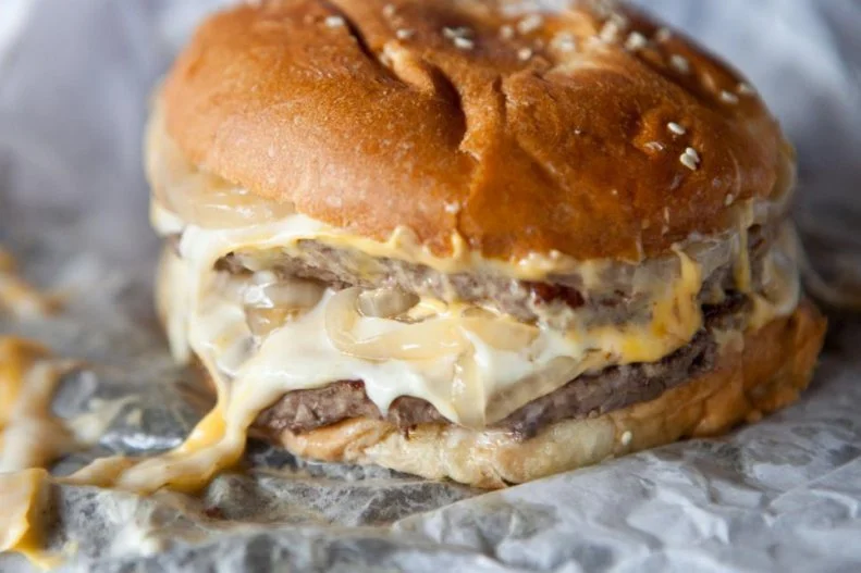 The hulking burger from this decades-old, nondescript tavern that bears no signage is a piece of Colorado culinary history. For more than 40 years, it's been calling to locals and travelers with its double layers of thin patties blanketed with melted Swiss and American cheese, and a coating of cream cheese and grilled onions, all combined in a sesame seed bun swaddled in wax paper. It's pretty much perfect as is, but those looking to pep it up even more can explore the condiment tray stocked with bowls of pepperoncini, raw onions, pickles, relish and other zesty accoutrements.