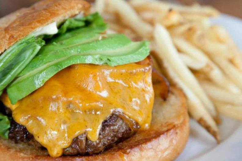 This trendy watering hole is a local pick for its excellent cocktails, communal atmosphere and stellar food like double-cut bacon, housemade barbecue chips and bone marrow lightened up with chimichurri. It's all good, but the signature Stout Burger is what really draws the dinner crowds. The splurgeworthy patty is served with beer cheese, garlic aioli, lettuce, pickle and fries, with optional add-ons like caramelized or fried onions, bacon and avocado. It can be paired with any brew from the constantly rotating selection of 21 taps and at least 40 different options by the bottle, but the staff here suggest that this decadent meal be washed down with a refreshing pale ale.