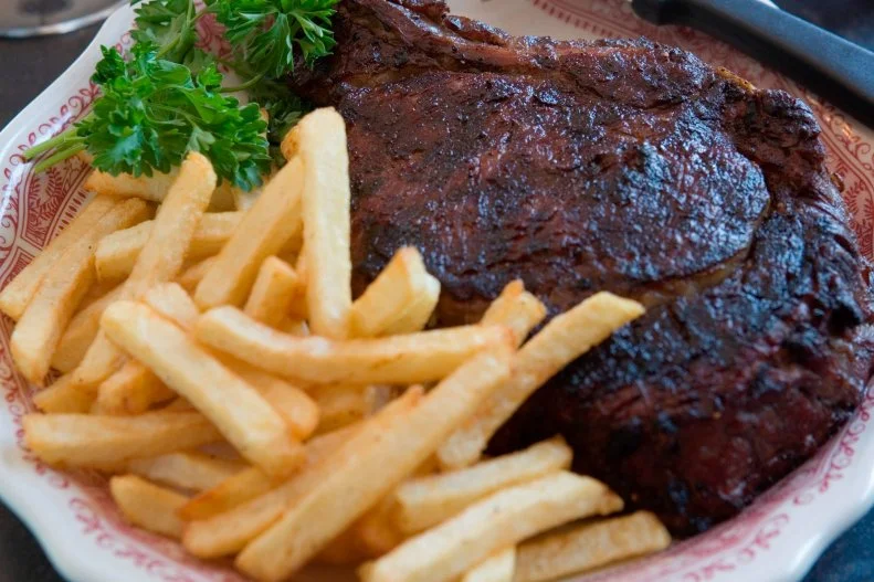 The Central Coast of Santa Maria-style barbecue draws from California's rich Spanish heritage. In a cooking method rooted in Mexican vaquero culture, beef (mainly whole tri-tip of sirloin) is seasoned with just salt, pepper and garlic salt, then grilled on a grate that gets lowered and raised above a pit of red-oak embers. These cuts are traditionally served with salsa, grilled garlic bread, local pinquito beans, green salad and macaroni salad. One of the best places to try this style of barbecue is at the Santa Maria Elks Lodge during special occasions or at a Central Coast steak specialist like The Hitching Post II, a famous Buellton spot hailed for its local wine selections and its appearance in the movie Sideways.