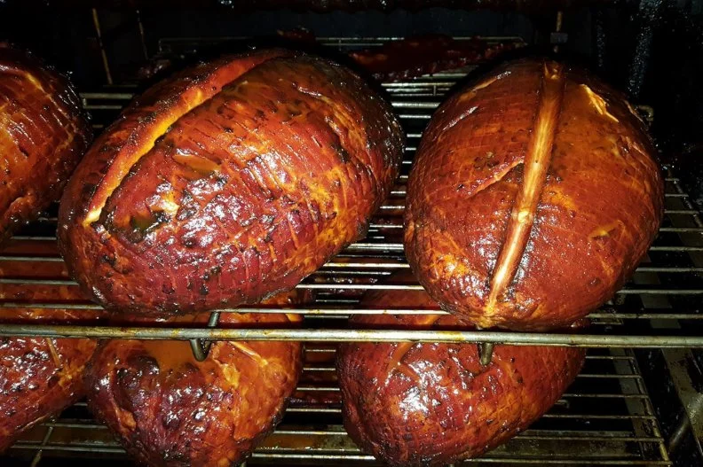 The seat of Kentucky's barbecue culture lies in the area west of I-65, the interstate that nearly cuts the state in half. Here, dry pork shoulder or Boston butt is cooked low and slow, 20 to 24 hours, in masonry pits elevated high over hickory coals. When it's done, the meat is pulled or chopped and served with some sort of vinegar sauce called "dip," just as it is in the rest of the state. "It's the most wonderful style," says Wes Berry, author of The Kentucky Barbecue Book. Some places, like Marion Pit Bar-B-Q in Marion, smoke sugar-cured hams in the same pits as the rest of the pork, picking up the essence of the vinegary dips that are used to baste the meat.