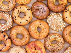 Assorted variety of different flavored freshly baked bagels in a full frame background on burlap viewed from above in an abstract pattern