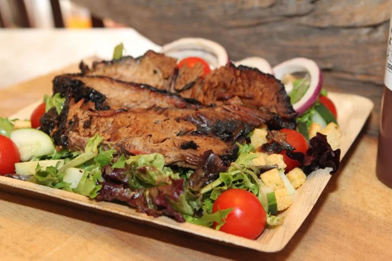 Long before Orlando got trendy with global cuisines and celebrity chefs, its ranchers, or Crackers, ate off the (swampy) land. Get a taste of their culinary lifestyle at Boggy Bottom BBQ, a lakeside, table-service indoor-outdoor restaurant located near Boggy Creek airboat rides. Start with Gator Bites â   marinated in a "secret recipe" for 24 hours, battered and fried to order, and served sizzling hot with a zesty mango sauce. Then move on to the pulled pork sandwich or smoked brisket salad, and help yourself to six sauces. How can you not add on a Swamp Ape IPA? The kids will find familiar foods, which will fuel them up for the sites like the gator pond and Native American Village, not to mention the fee-based airboat tours, bike rentals and gem-mining opportunities.