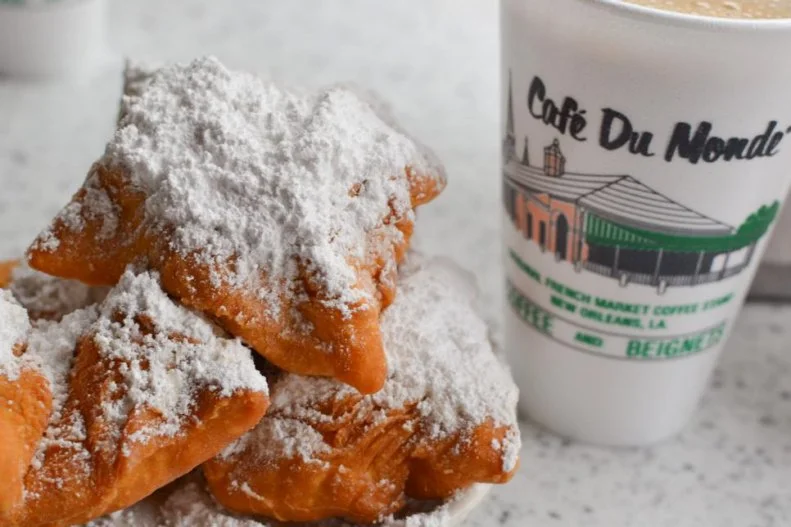 If you don't appreciate fluffy rounds of fried dough coated in a thick layer of powdered sugar, you must be a contrarian. Eating hot-out-of-the-fryer beignets paired with chicory-scented cafe au lait is a culinary rite of passage for anyone who visits New Orleans. Great versions can be found throughout the city, but there's no place like CafÃ© du Monde. The 24-hour French Quarter coffee shop has been serving those pillows of sugar-covered dough since 1862. The open-air shop allows leashed dogs on its covered patio. The management prefers that dog owners grab a seat around the perimeter, so the pups don't trip the servers who are carrying trays of hot coffee and sugary doughnuts.