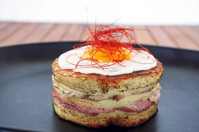 Cuban culture runs deep in Miami, so creating a grilled cheese with Cuban roots was a no-brainer for this swanky hotel restaurant. The sandwich contains the typical media noche ingredients — roasted pork and ham, mustard and mayo — but, for a nod to the French, Gruyère cheese is subbed for the Swiss. And because everyone loves a fried egg a la croque madame, one of those is added too. The sandwich, served on buttery brioche bread, is cut into a circle and pressed.