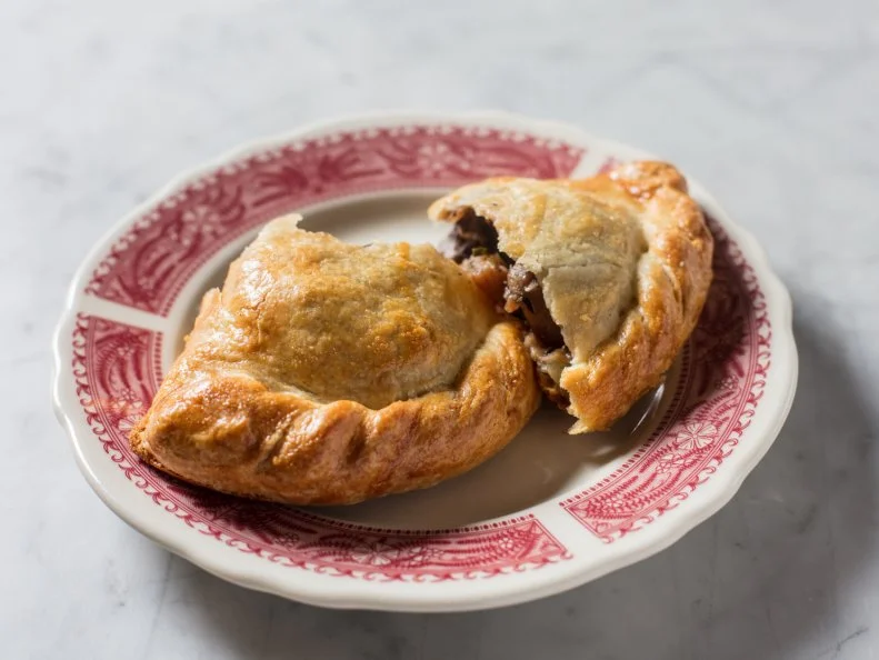 All the meat at this Manhattan spot is butchered in-house, with much of it showcased in gleaming display cases that beckon to hungry carnivores. A beef and red wine pasty is the perfect way to satisfy any meaty craving. To make the filling, beef shanks are braised in a mix of beef stock, pork trotters and red wine. Once the meat is fall-apart tender, the braising liquid is reduced to create a rich red wine sauce. The meat and sauce are folded with root vegetables like turnips, parsnips, carrots and celeriac, and the savory mixture is then stuffed and baked into a buttery crust. This pasty makes for a satisfying grab-and-go bite, but if you’ve got time to linger, eat in and pair it with a small glass of beer.  