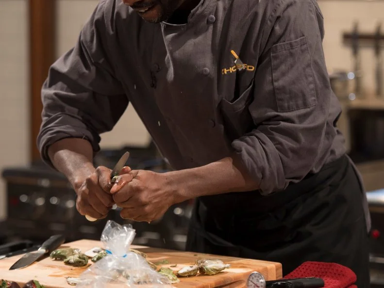 Chef Mark Bailey shucks his oysters, as seen on Food Network's Chopped, Season 27.