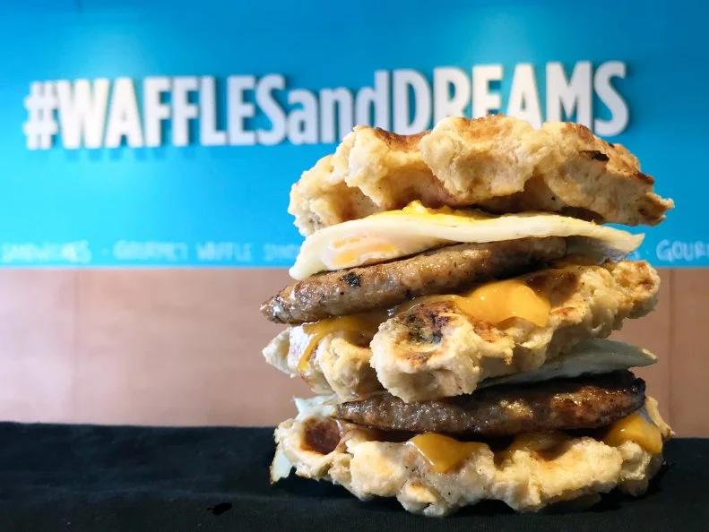 Growing up, Mason Rudarmel was a self-proclaimed Eggo kid. He took his love of the toaster pastry to new heights with the opening of Belgiis, where from-scratch waffles hold savory and sweet fillings. Rudarmel’s take on a breakfast sandwich is the restaurant’s trademark, a towering stack of aged Wisconsin cheddar, cage-free eggs, smoked bacon or sausage, maple syrup and a spicy red pepper aioli.