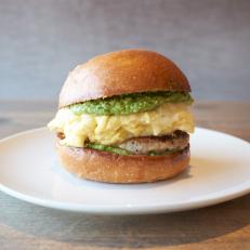 Growing up in Long Island conditioned Chef Michael Fiorelli to start his weekends with a classic New York bacon, egg and cheese. Now, at Love & Salt just blocks from the Pacific in Southern California, he crafts a tribute on a toasted brioche bun from Suzanne Goin’s The Larder stuffed with soft scrambled eggs, a savory chicken sausage patty, melted Fontina and a bright lemon-herb pesto.