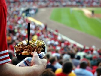 A man makes his way back to his seat with a fist full of nachos.