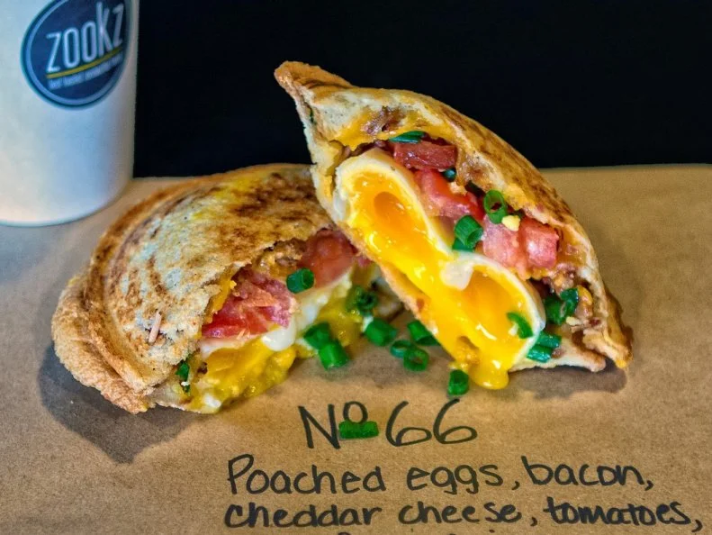 With five unique, stuffed-to-the-brim breakfast sandwiches all clocking in under $6, Zookz has become a breakfast mainstay in downtown Phoenix. The price-to-portion ratio isn’t the only thing to marvel at: The sandwiches have a rather unique aesthetic. Each sandwich is sealed and cooked, creating a crispy bread pocket loaded with eggs — typically poached, for maximal oozing — along with hearty breakfast meat, zingy sauces and melted cheese. They’re inspired by the sandwiches that owner Carole Meyer’s grandmother would make using what Meyer calls “a crude stove-top sandwich cooking device.” After 18 months of trial and error, Meyer succeeded in re-engineering the nostalgic, creative concoction.
http://zookzsandwiches.com/