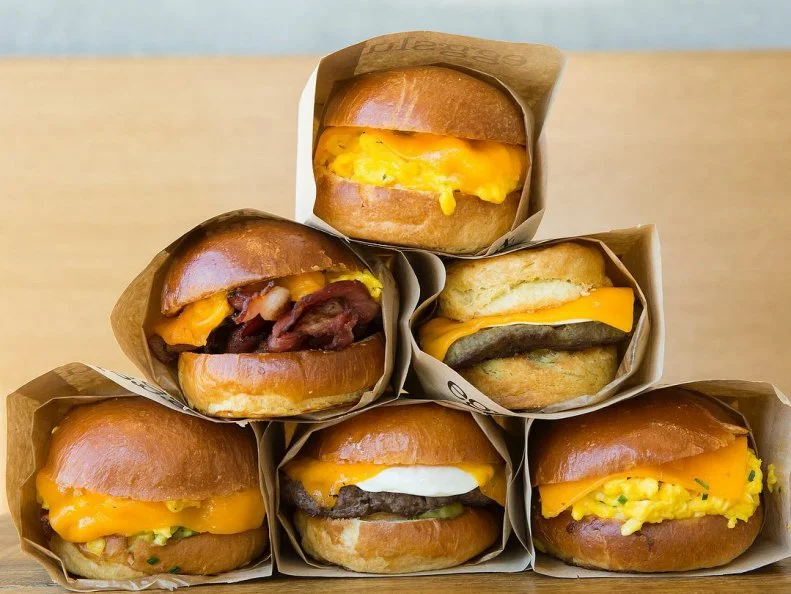 Is it the bold name that attracts meteoric crowds on weekday mornings? The locally made breads delivered fresh daily? Or is it simply the â  grammable allure of a golden, runny yolk cascading down a hillside of melted Cheddar, griddled bacon and a shiny brioche bun? Eggslut masters all of the above, compelling fans to endure two-hour lines for OG Grand Central food stallâ  s hip take on the basic breakfast sandwich formula. With four locations in Southern California and one in Las Vegas, the Eggslut empire is rising. Try the Fairfax, a classic bacon, egg and cheese, or a burger, topped with an over-medium egg. http://www.eggslut.com