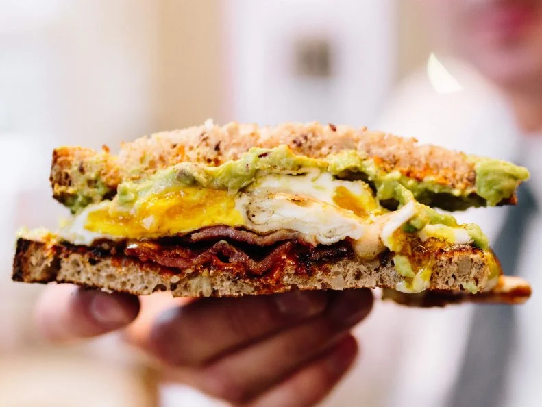 It didn’t take long once Mike and Patty opened their namesake sandwich shop — on a quiet corner in Boston’s Bay Village — for it to become an instant neighborhood fixture. Claustrophobes, take note: The storefront is tiny, with hardly enough room to turn around during the breakfast and lunch rushes. But what it lacks in size, it makes up for in genius menu creations between bread. The Fancy flies off the griddle at high speed every morning. It’s easy to see why: Eggs and thick-cut smoky bacon meet creamy avocado, sharp cheddar and red onion, all on slightly sweet multigrain bread with a spread of house mayo. The Banana Og X Fluff #2, a sweet creation featuring bruléed banana, Nutella and marshmallow fluff on buttered brioche, is the best morning sugar rush.
http://mikeandpattys.com/menu
