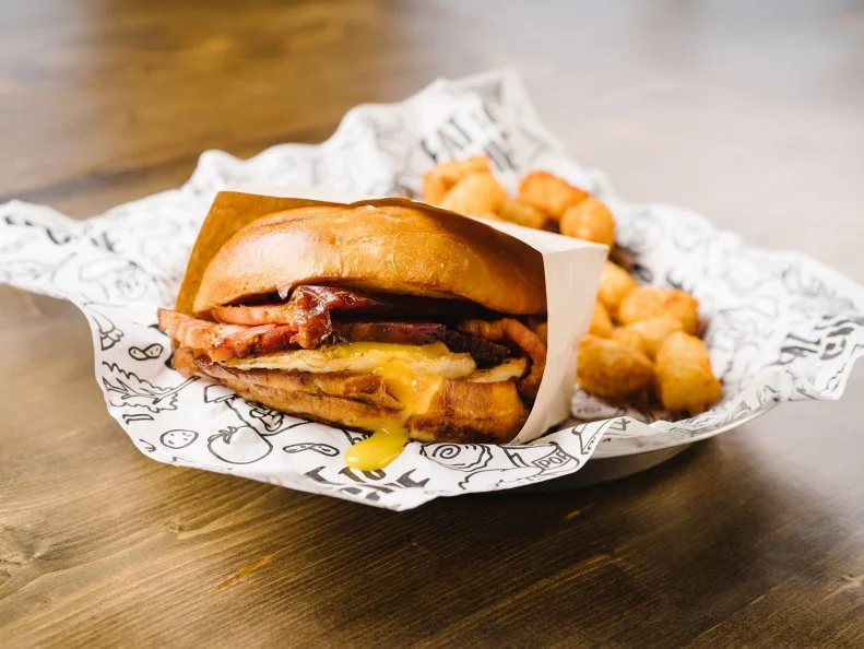 During its first six months of operation, this cafÃ© with a conscience donated more than 30,000 sandwiches to local people in need. Today, that number exceeds 1 million. Serial entrepreneur and Even Stevens founder Steve Down wanted to inject the local food scene with his pay-it-forward ethos. So, for every item sold at Even Stevens, a sandwich is donated to a local hungry person. Although it was hard to find investors willing to commit to the risky business model at first, the ever-growing throng of eager fans quickly convinced doubters. But enough about conscious capitalism. Weâ  re here to talk about breakfast, and the Even Stevensâ   breakfast sandwich is the best in the area. This maple-glazed sammy comes with two eggs, cheddar and a choice of bacon, ham, sausage, pork belly or avocado on a sweet Hawaiian bun. (Get the pork belly.) https://evenstevens.com/menu/