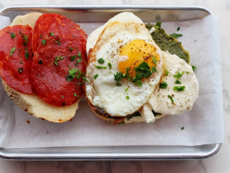 This retro brunch spot in Washington's Union Market specializes in handcrafted sodas, classic egg creams and ice cream floats, but the bagel breakfast sandwiches deserve a special shout out. Inspired by the classic New York soda shops of yesteryear, Buffalo & Bergen churns out bagels with that crusty-on-the-outside, chewy-on-the-inside texture that’s tough to find outside the Big Apple. We’re partial to the In Your FACE!, a mighty flavor combo consisting of fresh mozzarella, hot soppressata, pesto and a sunny-side-up egg, all brought together by the loving embrace of a housemade bagel. While you’re at it, treat yourself to a handcrafted soda made with one of 16 different flavored syrups, all made in-house. Nursing a hangover? No problem: You can chase it away by adding booze to any of their soda fountain creations. 
http://www.buffalobergendc.com/foods/