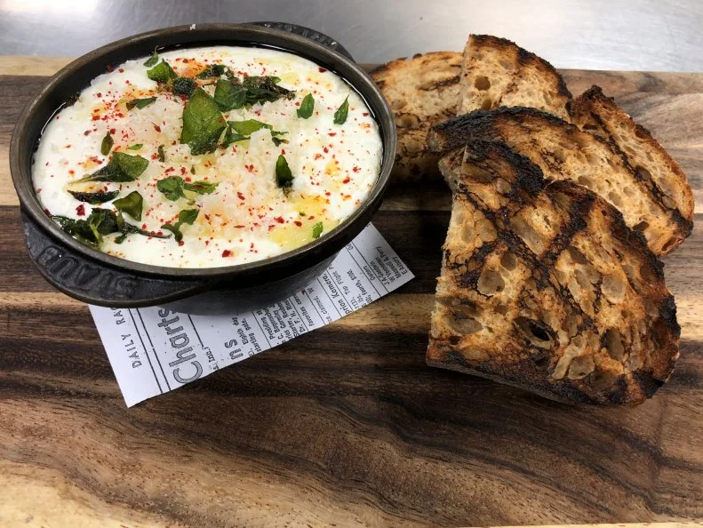 When it comes to hot and cheesy dishes, Kentucky is known for its eponymous Hot Brown sandwich, which was created at The Brown Hotel in the 1920s. But that’s not the only stellar cheese-smothered dish to come out of Kentucky’s hotel dining scene. The Whipped Ricotta at 21C Louisville’s Proof on Main may well be the state’s sleeper hit. Fresh Calabro ricotta is whipped until airy and smooth, then placed in a cast-iron dish and heated in the restaurant’s custom-built hearth. Once warm, the molten cheese is taken over the top with an unexpected yet winning finish of zesty grated horseradish, earthy truffle oil and local fried oregano. Every order comes with slabs of grilled bread from Blue Dog Bakery, and can be customized with an optional bourbon pairing. 