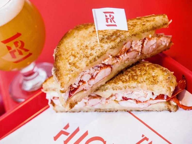 Highroller Lobster Co. started as a food cart with a mission to take Maine’s most famous export and remix it into a roster of unorthodox dishes. The quest continues at their brick-and-mortar location, where they’re breaking culinary rules with creations like a Lobster Cheese Crisp Taco and the best-selling Lobster Grilled Cheese. Purists may dismiss a dish that dares to combine seafood with cheese, but this grilled cheese proves that taking risks can result in delicious rewards. Chunks of local lobster claw and knuckle meat are layered onto locally baked English muffin bread, along with Jarlsberg Baby Swiss and Cabot Seriously Sharp Cheddar Cheese, then grilled until the bread is toasty and the cheese melty. Make the sandwich your own by adding bacon or avocado, and don’t sleep on the house sauces — they’re perfect for dipping. Options include a roasted red pepper and a lobster ghee, a vivid red clarified butter made with roasted lobster shells.