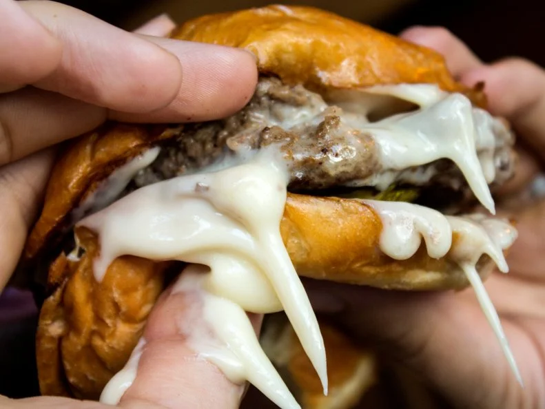 One of the favorite ways for Minnesotans to fortify themselves during the state’s notoriously cold, long winters is with meaty, cheesy comfort food. The Juicy Lucy, arguably one of the North Star State’s proudest culinary exports, features two hamburger patties stuffed and sealed with cheese. Approach that first bite with caution, or you’re likely to scald your mouth (and chin) with the ensuing avalanche of hot, gooey cheese. There’s a Twin Cities-wide debate on who makes the best, but none celebrate it quite like The Blue Door Pub with its dedicated menu of Blucys (named for the spot’s signature take on the celebrated burger). The eponymous flagship burger features a tangy core of blue cheese and garlic, while the Cajun Blucy is filled and topped with a spicy blend of ghost peppers and pepper Jack cheese. For a true taste of the region, opt for the Classic. Two Black Angus beef patties are sealed together with a mound of Land O’Lakes White American Cheese between them, then seared in a cast-iron pan and finished in the oven. Two lightly toasted, buttered local egg buns bookend this meaty, cheesy creation. Save room for a side of tater tots and a pint of local suds. 