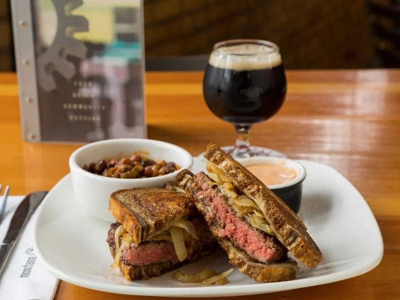 When locals dine out in Big Sky Country during the winter season, they opt for chill-busting dishes that offer both sustenance and comfort. Bozeman’s Montana Ale Works delivers on both counts, with a menu that’s stuffed with satisfying comfort food classics. Many of the dishes showcase regional ingredients. Take the Bison Patty Melt, for instance. This riff on the American grilled classic features a local bison patty piled with Swiss cheese and caramelized onions sandwiched between rye bread slices, all grilled until melty and toasted. It comes flanked by a side of sweet-smoky ranch beans topped with house-smoked pulled pork, as well as a ramekin of creamy-spicy MT 1000 Island dressing for dipping. Balance all that richness with Big Sky Brewing Company’s Ivan the Terrible Imperial Stout. Its dark chocolate and dried fruit notes perfectly offset the creaminess of the melted cheese.