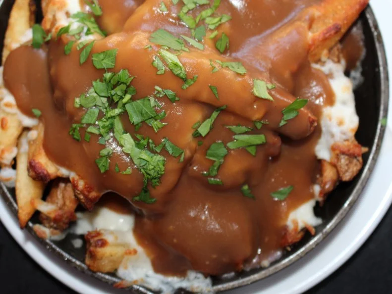 French fries with melted mozzarella and gravy have been a Garden State diner staple since the 1940s, but it wasn’t until the 1970s that the dish gained in popularity and garnered its Disco Fries moniker, thanks to the late-night revelers who made it their go-to order after a night out dancing. At Left Bank Burger Bar, owners and Jersey City natives Nina Colon and Daniel DeAlmeid pay homage to this staple from their home state with a cheesy, gravy-soaked version of their own. To make the dish, they heap hand-cut fries with grated mozzarella cheese and homemade beef gravy, then pile the whole lot into a skillet and bake it until gooey and golden. Add the richness with an optional upgrade of chopped bacon or a runny fried egg. 