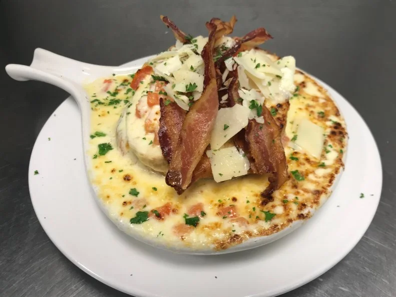 Said to have been invented in Pittsburgh, the Turkey Devonshire is Pennsylvania’s answer to the Kentucky Hot Brown. The hot, open-faced turkey sandwich is a menu mainstay at the The Union Grill, a neighborhood fixture that’s been serving old-school comfort food since the early ‘90s. According to owner Eric Nernberg, the legendary dish was created by American-Sicilian restaurateur Frank Blandi at The Stratford Club, and named after one of his other establishments, Devonshire. At Union Grill, Chef Victor Tome tops toasted French bread with thick slices of brined-then-roasted turkey breast and an even layer of diced tomatoes. Instead of a roux-based bechamel sauce, which he found too heavy, he drenches the open-faced sandwich with a velvety sauce made from heavy cream thickened with Swiss, Provolone and mild cheddar cheeses. He browns the dish under the broiler, then finishes it with applewood-smoked bacon and shaved Parmesan, Pecorino Romano and Asiago cheeses. With upwards of 175 sandwiches served daily, the restaurant’s cooking space has been expanded into a second kitchen to keep up with demand.