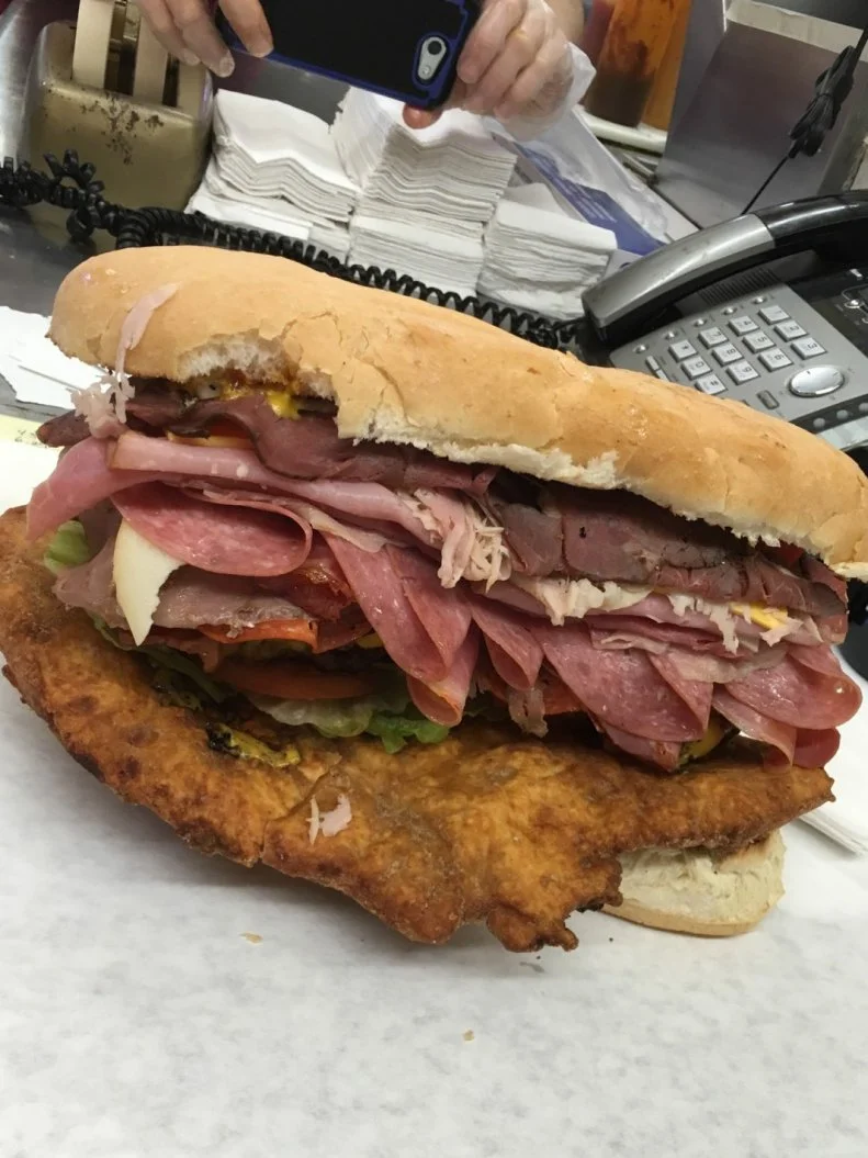 Third-generation owner John Brooks says it was a night his father spent watching a show at the Des Moines playhouse that inspired the shop’s now-beloved Dad’s Killer sandwich. As soon as the curtain closed, the elder Brooks headed to B & B Grocery to create this one-pound-plus behometh that brings together roast beef, corned beef, smoked ham, turkey and a trio of cheeses (Swiss, pepper and American). The fillings are piled into an Italian hoagie roll, then topped with lettuce, tomatoes, Kosher pickles, mustard, mayo and Italian dressing. This overstuffed sandwich is now one of the most-popular lunch items at this family-owned operation, where current owners John and Joe serve about 180 locals per day. 