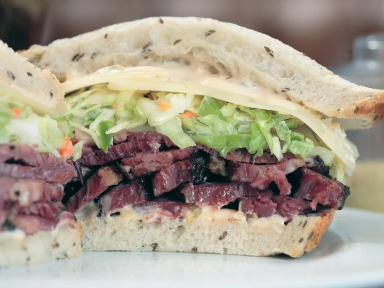 Though the pastrami isn’t the only standout on this spot’s multi-page menu, which spans from grilled liver and onions to fish and chips, the cured beef has most-definitely achieved cult status. Langer’s has been slicing up pastrami for ardent fans since 1947 and stacking up accolades along the way (awards include the James Beard Foundation’s Regional America’s Classics). The cured beef is so in demand that Langer’s started an overnight delivery service for the contiguous 48 states. Find out what all the fuss is about by ordering the pastrami in the famous No. 19. This iconic sandwich starts with toasty rye bread that’s crisped in the oven after arriving fresh from the bakery. The sturdy slices hold up to the juicy brined beef, which is crowned with a thick layer of coleslaw, a slice of Swiss cheese and, finally, a slather of Russian dressing.