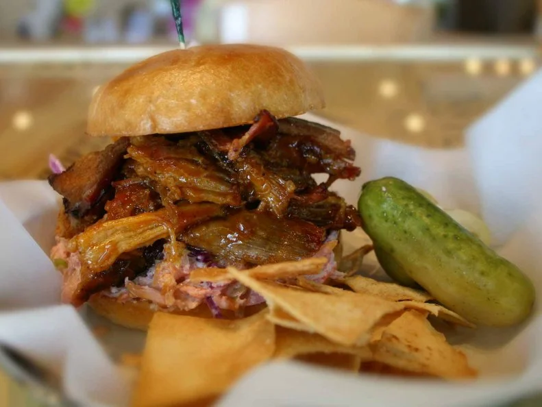 This Smyrna neighborhood joint masterfully merges concepts and cuisines. Operating as a deli by day and a bistro by night, Muss & Turner tweaks Southern specialties with Jewish tradition. A prime example is the Bucky Goldstein, which features slow-roasted Rosewood Ranch Wagyu beef brisket, pickles and onion rings piled on a mustard-slicked bun and slathered with Carolina barbecue sauce. Another standout is the Swifty's Dream (pictured above). Tangy horseradish slaw cuts through the rich combination of barbecued pork shoulder and crisp slabs of Nueske's bacon that are piled into this Georgia-style pulled pork sandwich.