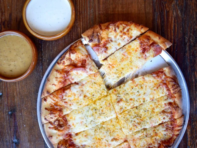 Chicago’s culinary calling card may be its deep-dish-style pizza, but there’s another pie vying for the honor: Quad Cities-style pizza, named for the small region of four cities located where Iowa meets Illinois. In the Windy City, you can find it at family-friendly pizzeria Roots Handmade Pizza, where the pies honor the pizza style’s defining characteristics: a malt-heavy, chewy-nutty thin crust with a chile flake- and cayenne-laced red sauce, served in scissor-cut strips. There’s a pie for every palate, with toppings like housemade sausage, taco fillings or short rib, as well as a specialty pies created by local guest chefs. Kids get pizza dough to play with throughout the meal and a kids’ menu to color on; kids’ non-pizza options include mini corn dogs or housemade fettuccine with butter. The mozzarella sticks — using housemade mozzarella and garlic-herbed breadcrumbs — are perfect for sharing. Build in a family outing and stop by Roots’ West Town location after a day at Kids Science Labs or Little Adventures, or the Lincoln Square location after visiting Lillstreet Art Center and Winnemac Park.