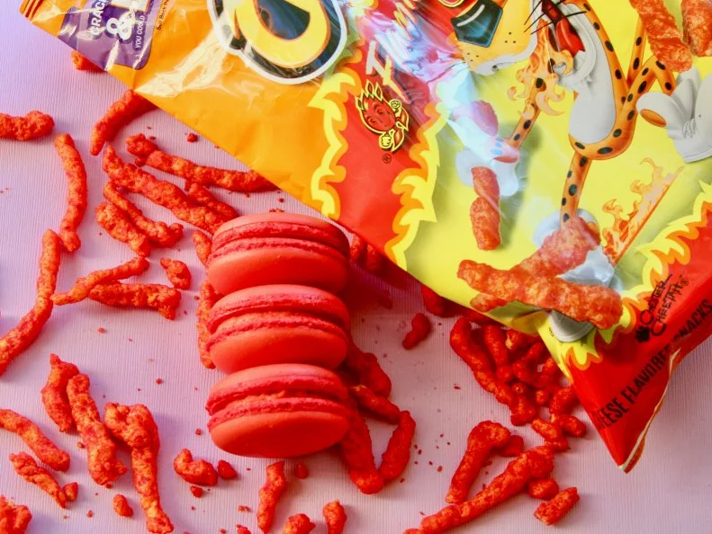 The rotating flavors at Treney Juarez’s macaron stand mix high with low. Some, like the fig-goat cheese and salted caramel, skew more classically French, while others, such as the recently debuted hot Cheetos and sour apple, are inspired by the Houston pastry chef’s own guilty pleasures. The Flamin’ Hot Cheetos cookie calls for white chocolate ganache blended with crushed puffs and macaron shells colored a bright red to match.