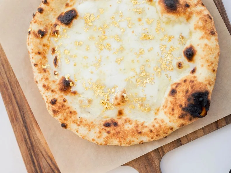 It may not be the most-expensive pizza on this list, but this off-menu special at Ray’s & Stark Bar certainly shines the brightest. Chef Fernando Darin puts a Midas touch on each pie, pulling the cheese-topped disc from an 800-degree wood-burning oven and finishing it with aged balsamic and edible gold. It seems fitting that this blinged-out pie is served within a (glittering) stone’s throw of the Los Angeles County Museum of Art.
