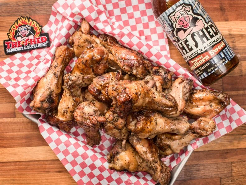 The Shed is truly a family affair. Brad Orrison and his sister Brooke Lewis built the takeout BBQ and blues joint themselves (with a pile of odds and ends Brad stashed away from his college days dumpster diving) in 2001, and then set to work perfecting their barbecue technique. Brother Brett, a sound engineer who had worked at House of Blues in New Orleans, brought his music-industry expertise to the venture. Mom Linda does the marketing, “G-Maw” staffs the beer bar and “Daddy O” Craig is the “Saucerer,” making BBQ sauce for The Shed’s two takeout locations and its online shop. It’s no surprise that family recipes like G-Maw’s Famous Beans and Daddy O’s Creamy Cole Slaw are on the menu along with pecan wood-smoked ribs, chicken and sausage.