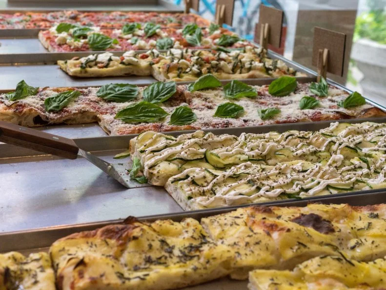 The offerings at Rione bear no resemblance to your average slice on a paper plate. This Center City shop serves pizza al taglio, a rectangular-shaped Roman specialty with simple toppings scattered across a lighter-than-it-looks crust. Owners Francesco and Alison Crovetti keep it fresh with a daily-changing variety of options sold by the piece, each ranging in price from $2.50 to $4.25. The traditional Margherita ($3.25) is a solid intro to the style, but don’t sleep on the sauceless potato and rosemary ($3.50) or the best-selling Diavola ($3.75) studded with spicy soppressata.