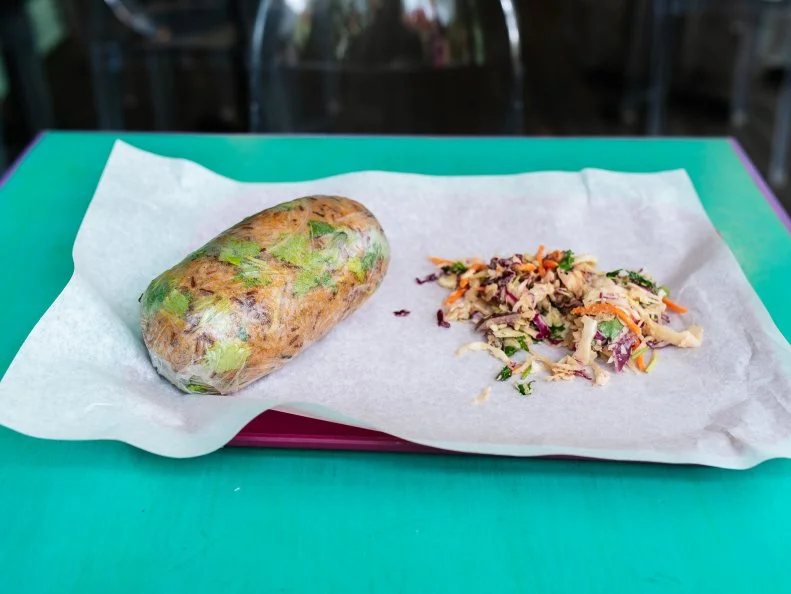 Lona’s Lil Eats delivers big on both portion size and flavor. Stumped on where to start? Begin with their giant rice paper wraps. Similar to spring rolls (but sized way up), these fan favorites come stuffed with Thai and Chinese fillings. Make your own or stick to beloved menu standards like the #5 Big Thai ($9.25): grilled chicken, stir-fried rice and lime-ginger peanut sauce, all tucked into a massive wrapper. No matter what you pick, it’ll be right around $10, and well worth every penny.