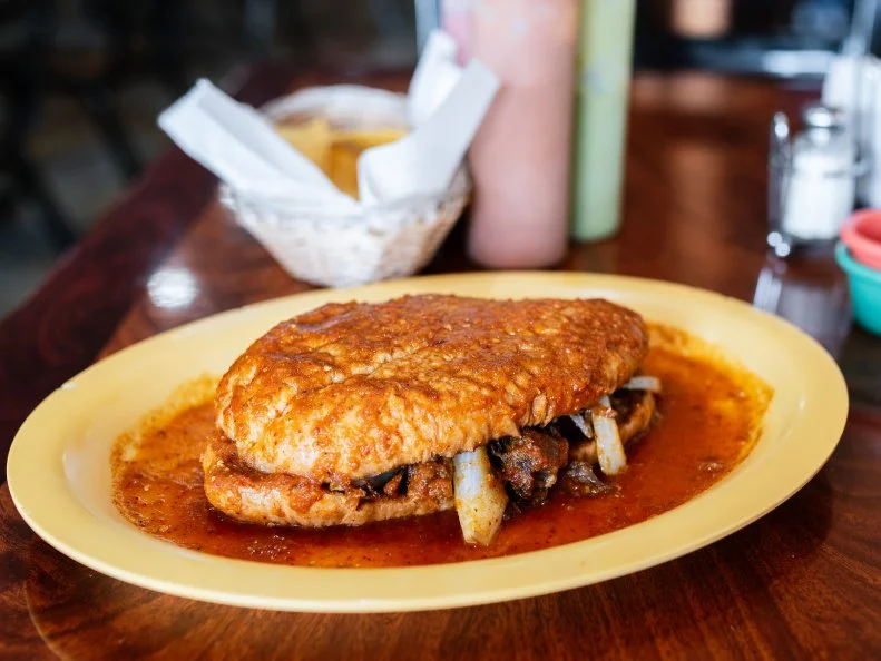 Bring your appetite if you plan to tackle the torta ahogada (drowned sandwich) at Taqueria Durango. It’s roughly the size of a football. For $7.99, a massive bolillo roll gets stuffed with crisp carnitas and grilled onions, then drenched in the smoky-spicy red chile sauce that gives this classic Mexican sandwich its name. Eating with your hands is not an option. This is a knife-and-fork, multiple-napkin affair.