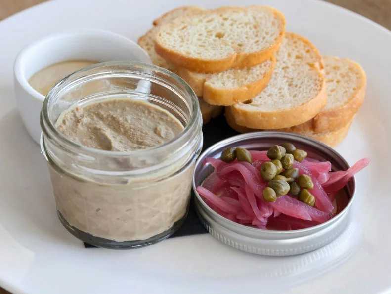 Chicken liver pate served in a cute jar with pickled onions, chives, mustard and bread