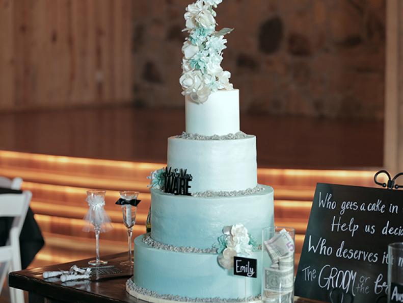 As seen on Food Network's Dallas Cakes, the bride envisioned the sweeping blue look of crystal carribean waters and Creme de la Creme delivered the simple but elegant blue Ombre buttercream frosting covering a traditional white cake. To compete the beach theme, crushed rock candy surrounded each tier to give it a beach glass look.