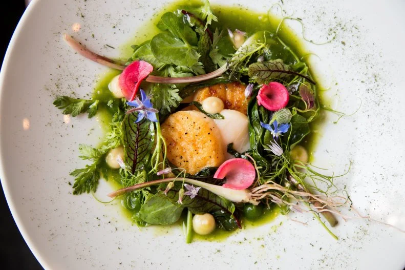 In a bold move, chef Paul Verica uprooted his award-winning restaurant, Heritage, moved it from the quiet suburb of Waxhaw to a high-traffic location about a mile from downtown Charlotte, then changed its name to The Stanley in a nod to the new neighborhood. The James Beard Award nominee will continue to work with his son, Alex, in the sous-chef role. Joining them is Chef Ben Philpott, making this team a triple threat in the kitchen. In this larger space, they’re ramping up their offerings, but will keep their infamous tasting menus for diners who like surprises. Small plates such as “asparagus as many ways as we could think of” are beautiful interpretations of seasonal ingredients. Steaks, chops, poultry, and fish will satisfy heartier appetites. 