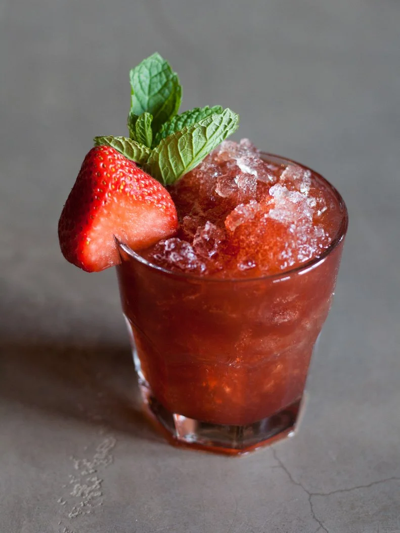 After a customer at the modern lounge joked that she could just drink the dressing from a spinach-strawberry salad, co-owner and lounge manager Rich West started experimenting. The resulting drink shakes muddled strawberry and mint with strawberry purée, lemon and bourbon, all fine-strained over crushed ice and garnished with mint and a strawberry slice.