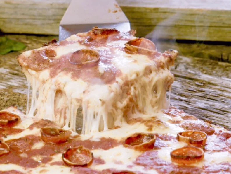 What started as a party supply store and sub shop in 1956 has morphed into one of Metro Detroit's longest-running pizzerias. Located on the outskirts of Motor City in Eastpointe, The Original Buscemi's is one of the few local spots that offers slices of Detroit's famous thick-crusted square pizza made in the traditional style of cheese first, then sauce. It all starts with fresh dough that's made daily. The dough is blanketed with a thick layer of 100% real mozzarella Grande cheese, then slathered with homemade tomato sauce made from vine-ripened California tomatoes. Many of the pizzas are also finished with a flurry of dry-aged pepperoni. Once ready, the pizza is cooked until the crust turns golden and chewy and the cheese begins bubbling down the sides.